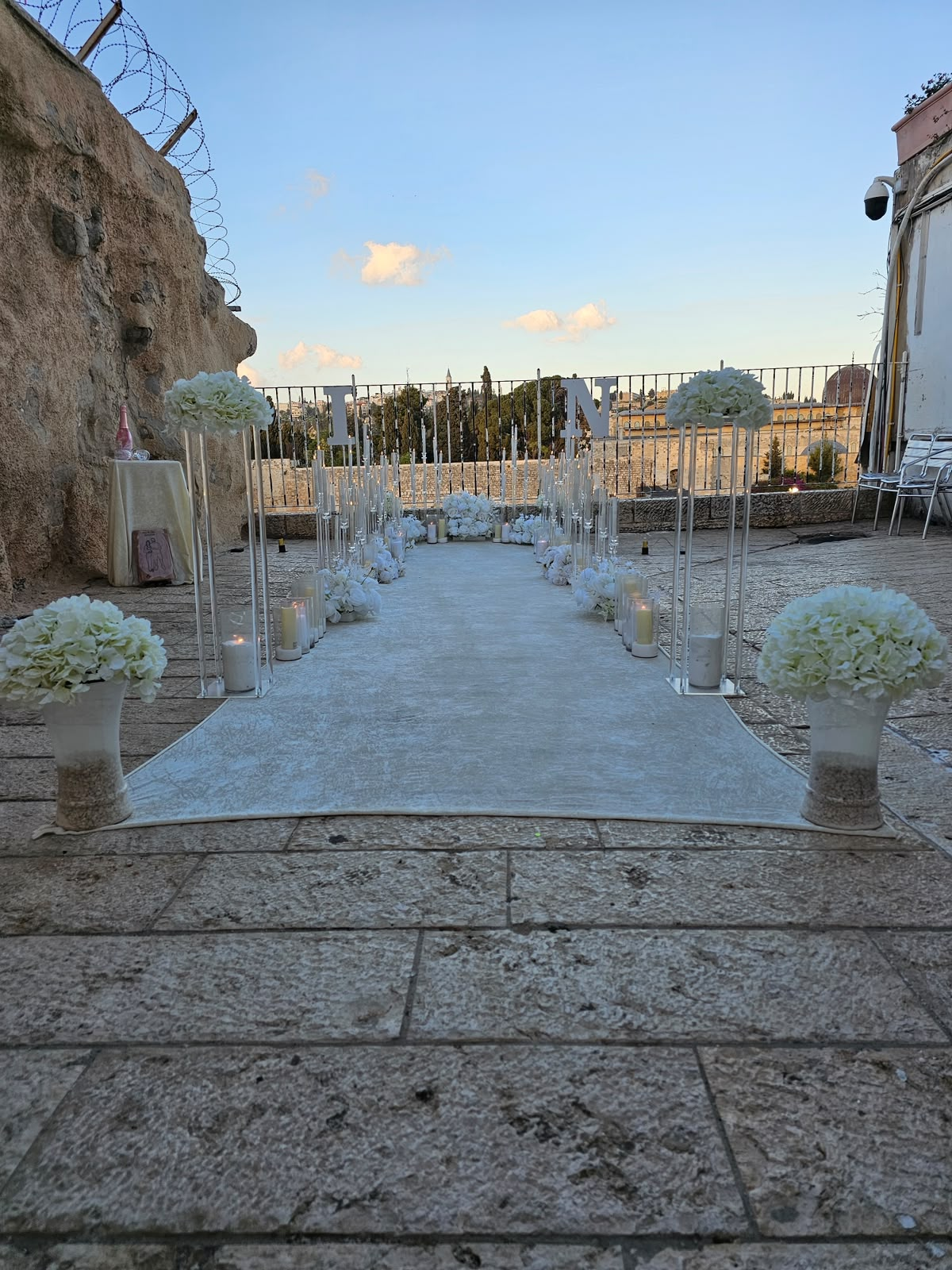 שטיח לבן עם פמוטים ואותיות מול הכותל